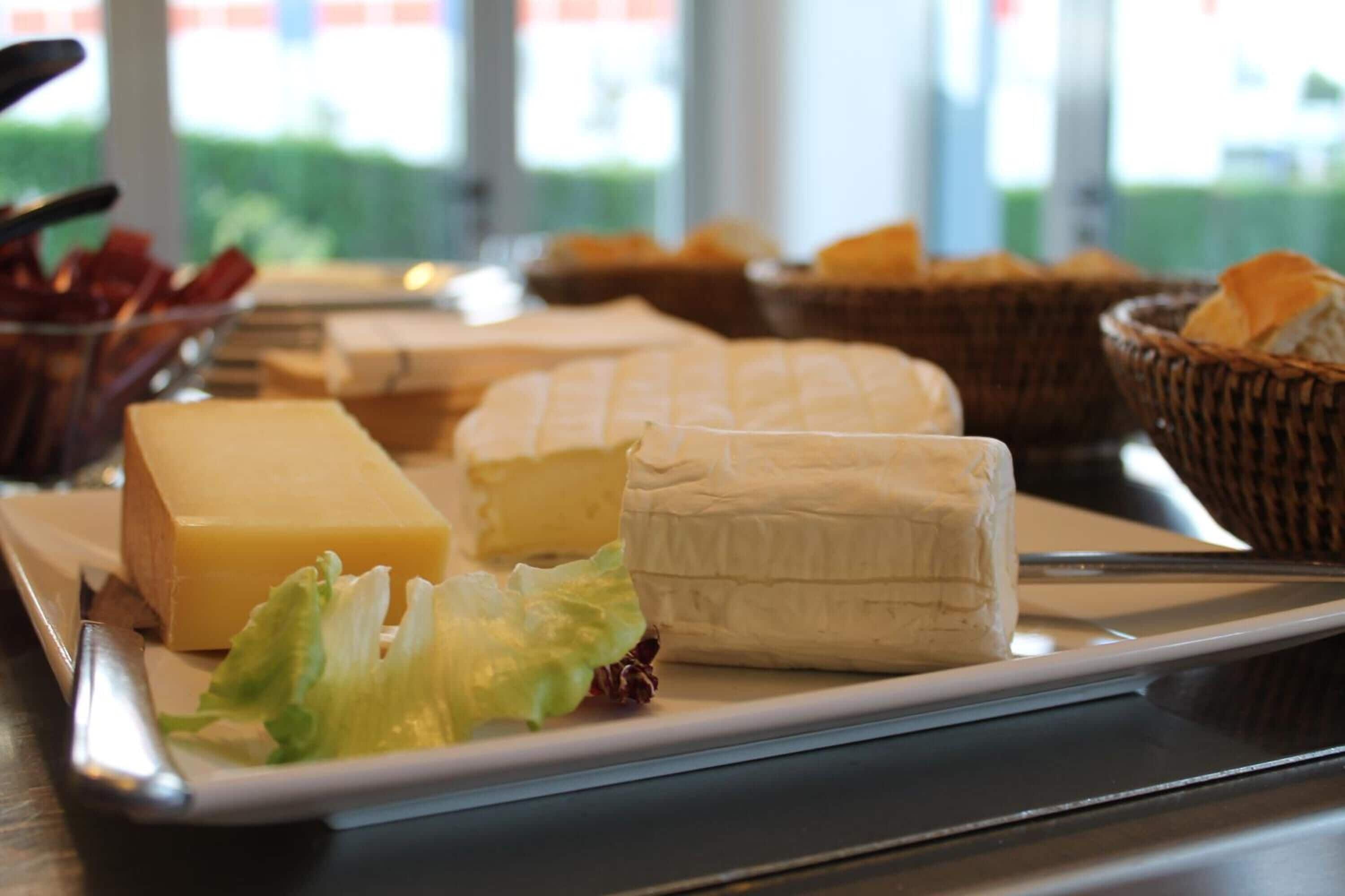 Un plateau de fromages comprenant différents types de fromages et des crackers, le tout présenté sur un plateau.