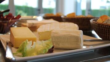 Un plateau de fromages comprenant différents types de fromages et des crackers, le tout présenté sur un plateau.