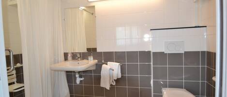 A bathroom with a sink, toilet, and shower curtain.