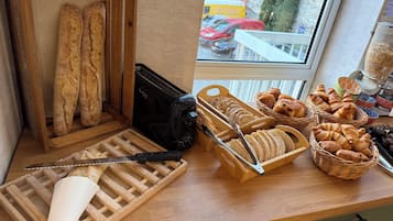 Exposição de pães, um cortador de pão e cestos de pastelaria.