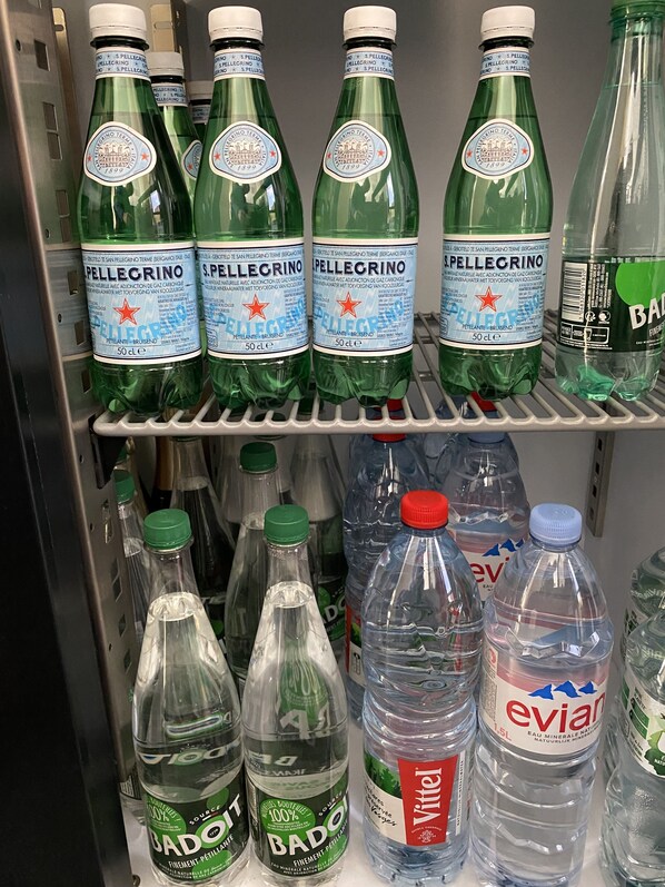 A refrigerated display with Pellegrino and Bado water bottles.