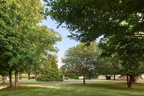 A park with various trees and a well-maintained lawn. - Campanile NATURE - Niort Est La Crèche (La Creche)