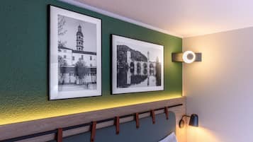 Dos fotografías en blanco y negro de edificios sobre un muro verde.