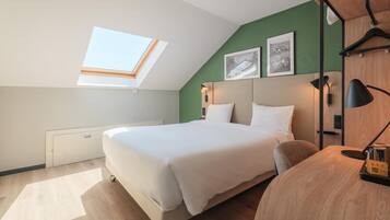 A modern hotel room with a skylight, a large bed, a bedside table, a chair, and a wall-mounted lamp.