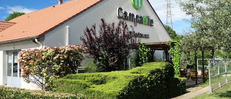 A building with a sign reading "Camoarte Restaurant" and a red-tiled roof.