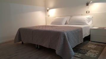 A bedroom with a bed, bedside tables, and a rug.