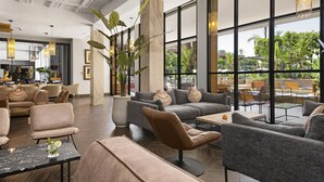Un vaste espace de détente doté de sièges confortables, de grandes fenêtres offrant une vue sur l’extérieur et d’un aménagement intérieur moderne.