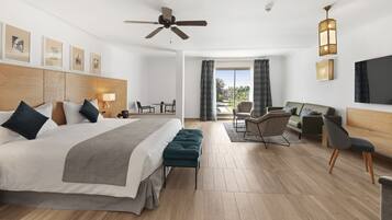 Una habitación de hotel moderna con una cama grande, un escritorio, un sofá y un balcón con cortinas.