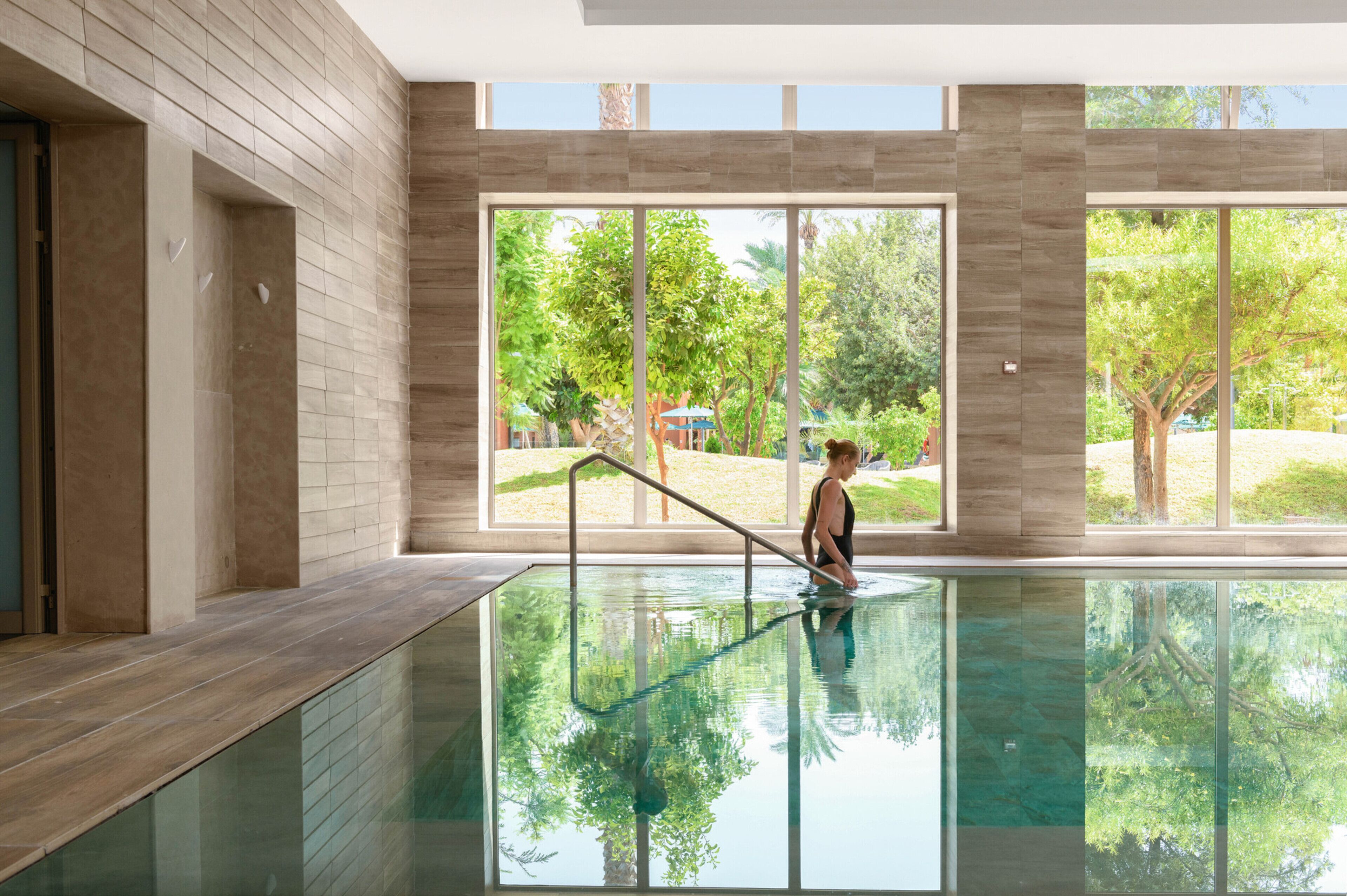 Une piscine avec vue sur les arbres et un bâtiment en arrière-plan.