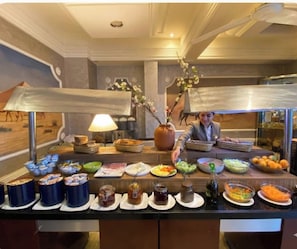 A buffet setup with various food items and condiments.