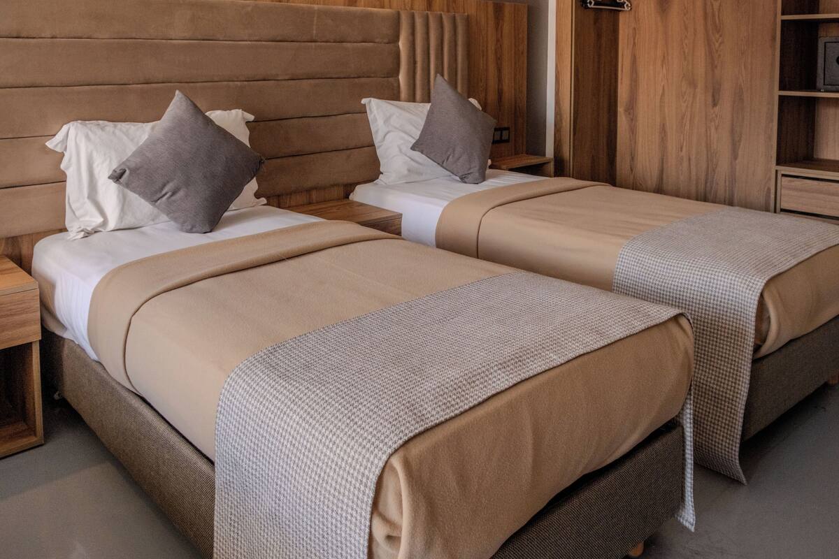 A double bed with a headboard, a bedside table, and a nightstand.
