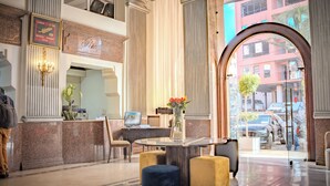 A hotel lobby with a reception desk, seating area, and a large window offering a view of the street. - Imperial Holiday Hôtel & spa (Marrakech)