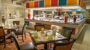 A hotel dining area with tables set for service, a buffet counter, and a modern interior design. - Peermont Metcourt Inn at The Grand Palm Resort (Gaborone)