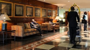 A lobby with a checkered floor, patterned wall decor, and a reception area with a desk and chairs. - Peermont Metcourt Inn at The Grand Palm Resort (Gaborone)