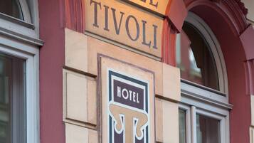 Un letrero de hotel con el nombre 'HOTEL TIVOLI' y un logotipo que muestra una 'T' y una 'V' estilizadas.