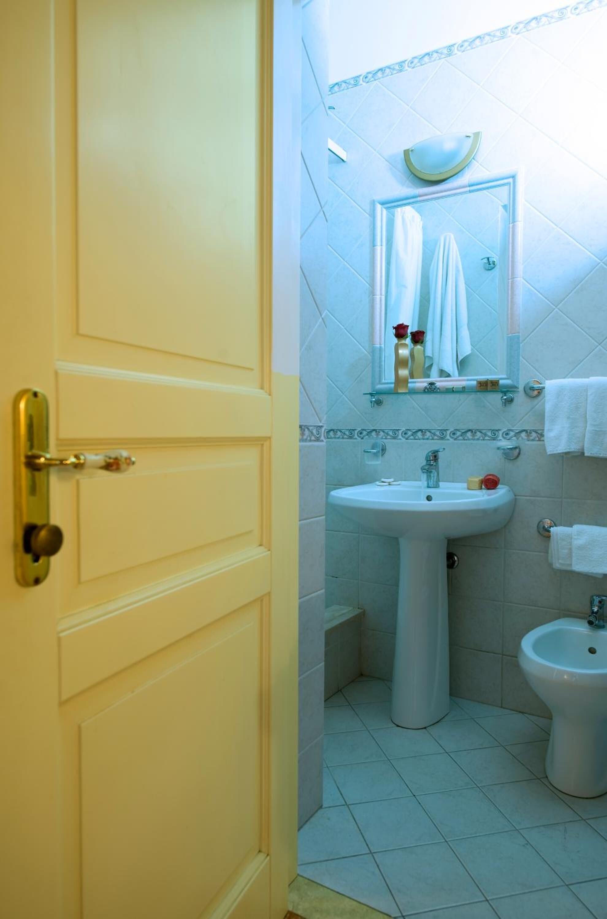A bathroom with a white sink, a mirror, and a bidet.