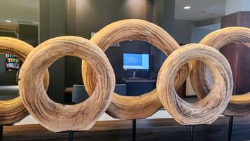 A reception area with a modern design, featuring a series of wooden rings displayed on stands.