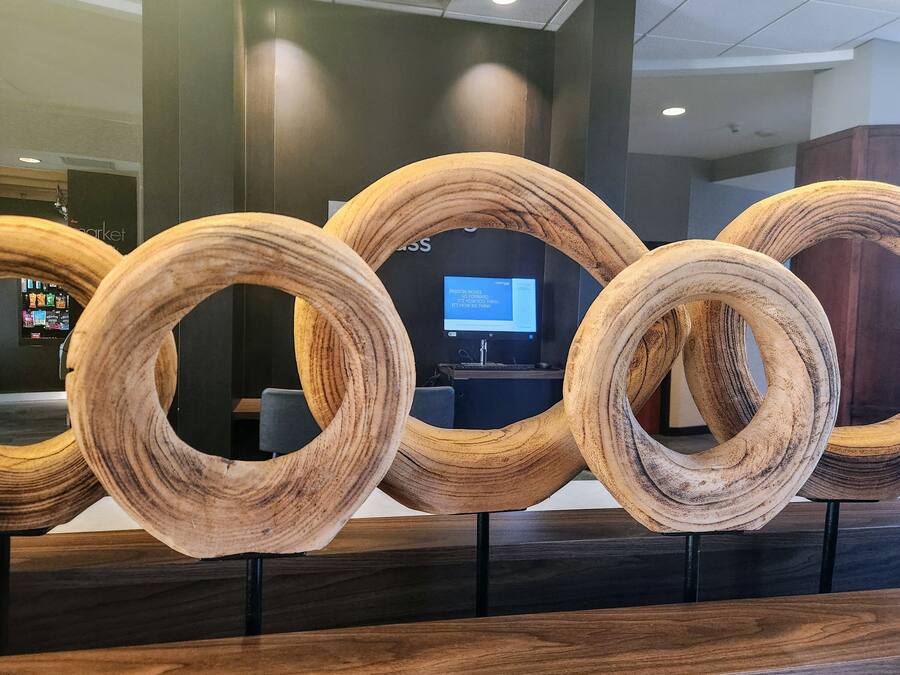 A reception area with a modern design, featuring a series of wooden rings displayed on stands.