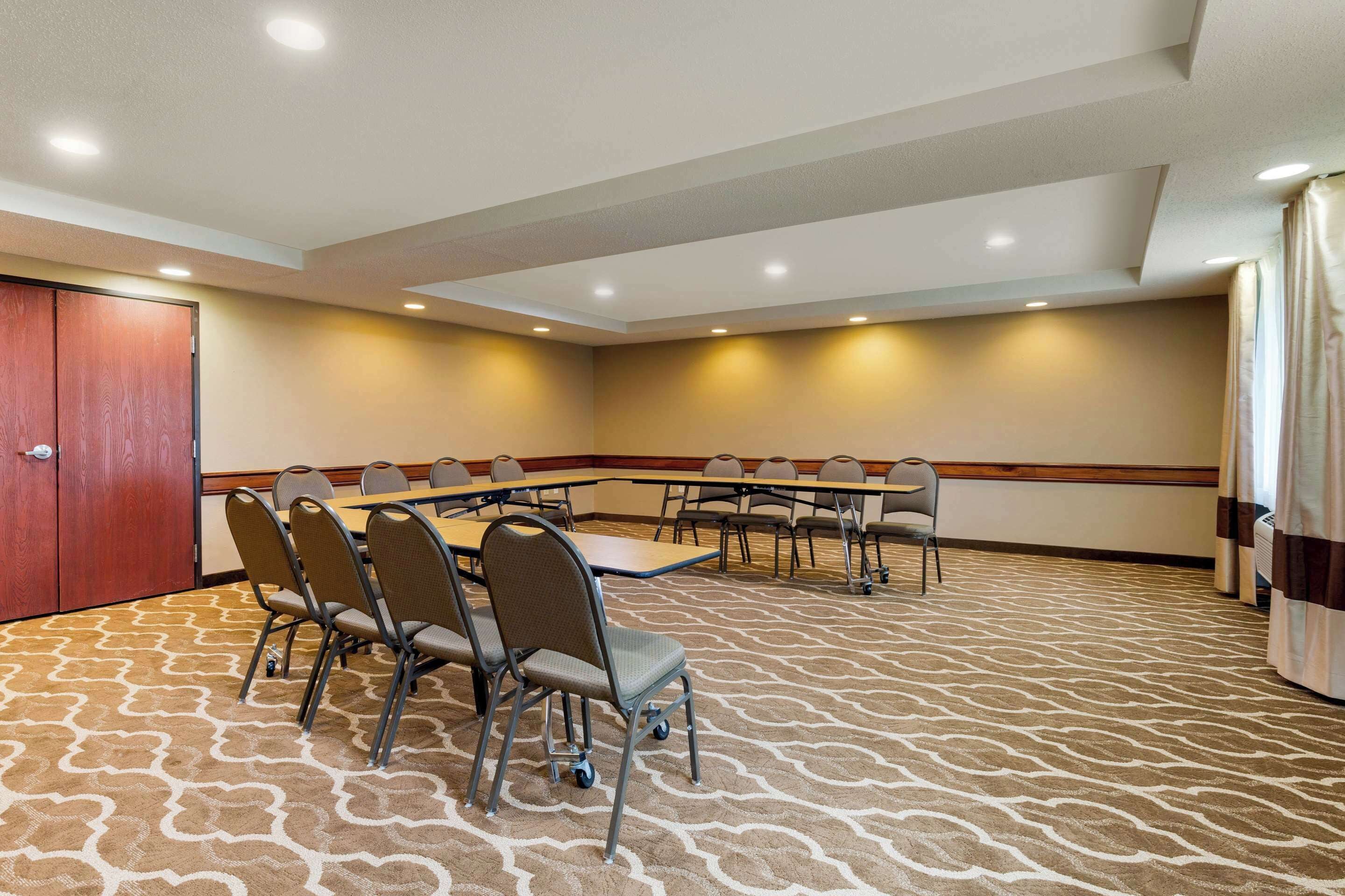 A conference room with a long table and chairs, carpeted floor, and recessed lighting.