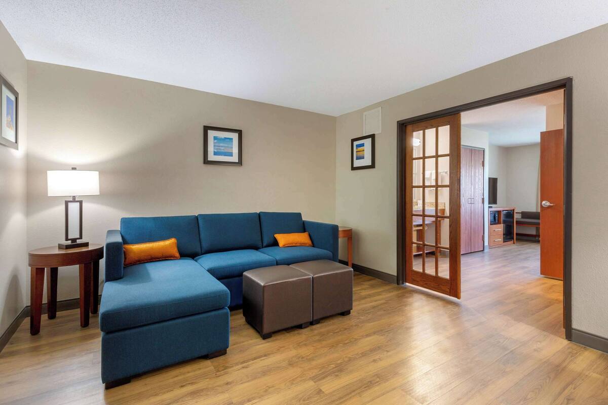 Una sala de estar con un sofá modular, un reposapiés y una lámpara.
