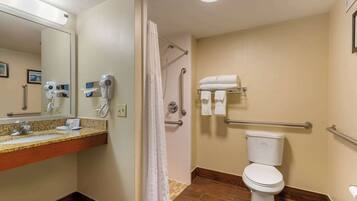 A bathroom with a sink, mirror, towel rack, shower, and toilet.