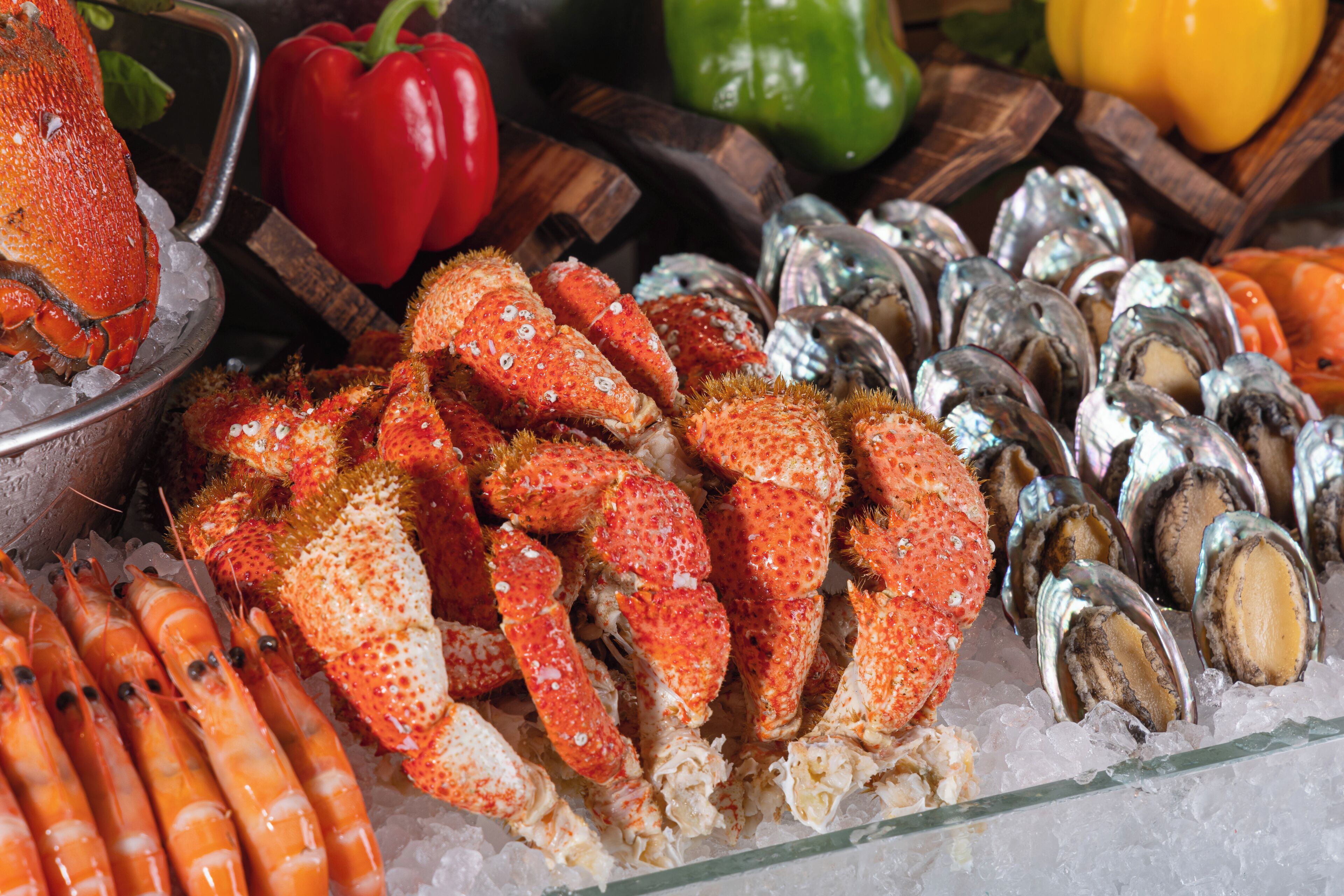 Une variété de fruits de mer, notamment des homards, des crevettes et des huîtres, servis sur un lit de glace.