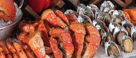 Une variété de fruits de mer, notamment des homards, des crevettes et des huîtres, servis sur un lit de glace.