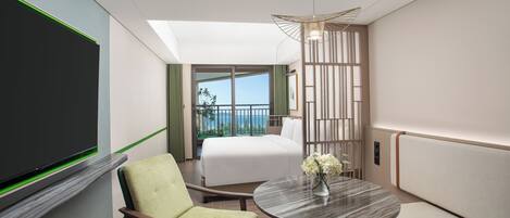 A hotel room with a bed, a chair, a round table with a vase, a TV, and a balcony with a view.