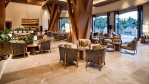 A spacious lobby with modern furniture, large wooden beams, and a view of palm trees. - Holiday Inn Resort Sanya Bay by IHG (Sanya)