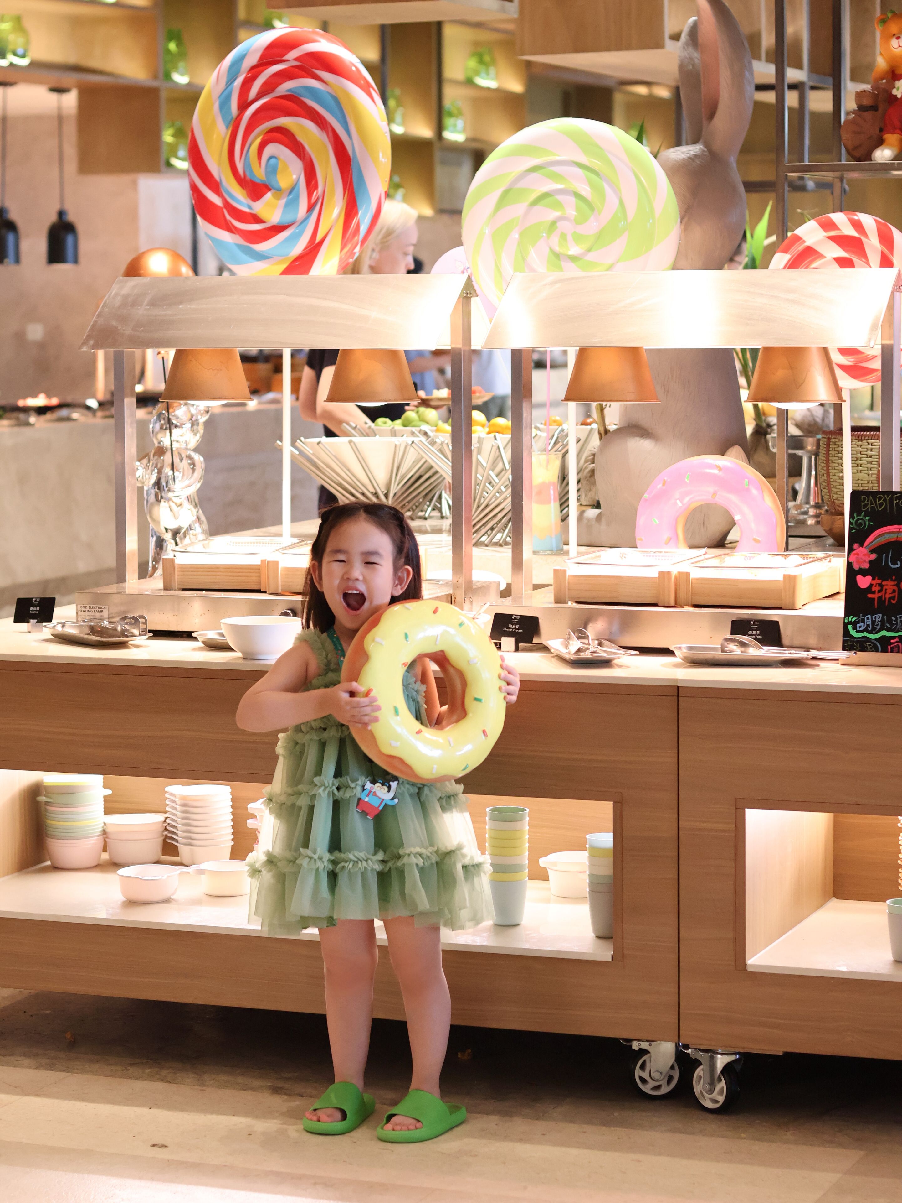 A child holding a donut-shaped toy in a store with various items on display.