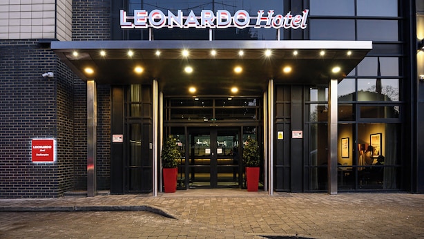 The exterior of the Leonardo Hotel with a modern entrance, two potted plants, and a sign indicating it is a hotel. - Leonardo Hotel Southampton  (Southampton)