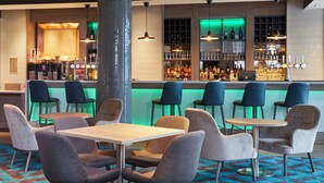 A bar area with seating and a counter. - Leonardo Hotel Southampton  (Southampton)