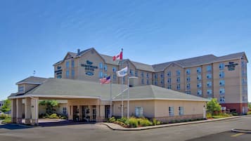 Un hôtel doté d’une entrée imposante, de plusieurs étages et de drapeaux.