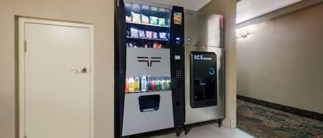 Una macchina distributrice con diverse bevande e snack, una porta e un distributore di ghiaccio.