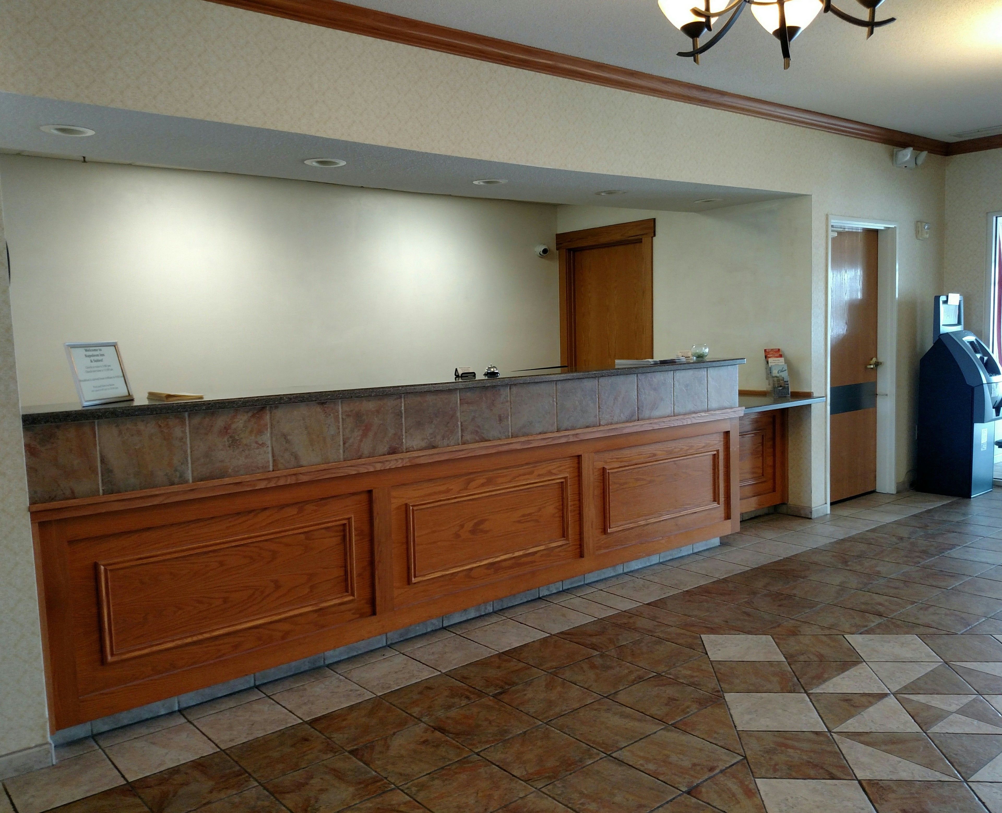 A reception area with a wooden counter, a door, and a self-service kiosk.