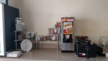 A kitchenette with a coffee machine, a waffle maker, and a coffee dispenser.