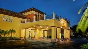 Een hotel met een overdekte ingang, een bord met de tekst 'Homewood Suites by Hilton', en een heldere lucht.