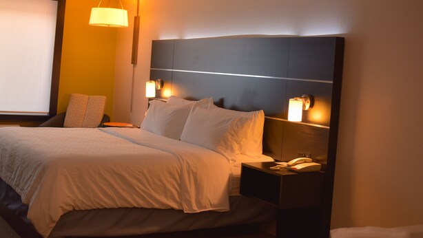 A hotel room with a bed, bedside lamps, a telephone, and a window. - Holiday Inn Express & Suites Maryville by IHG (Maryville)