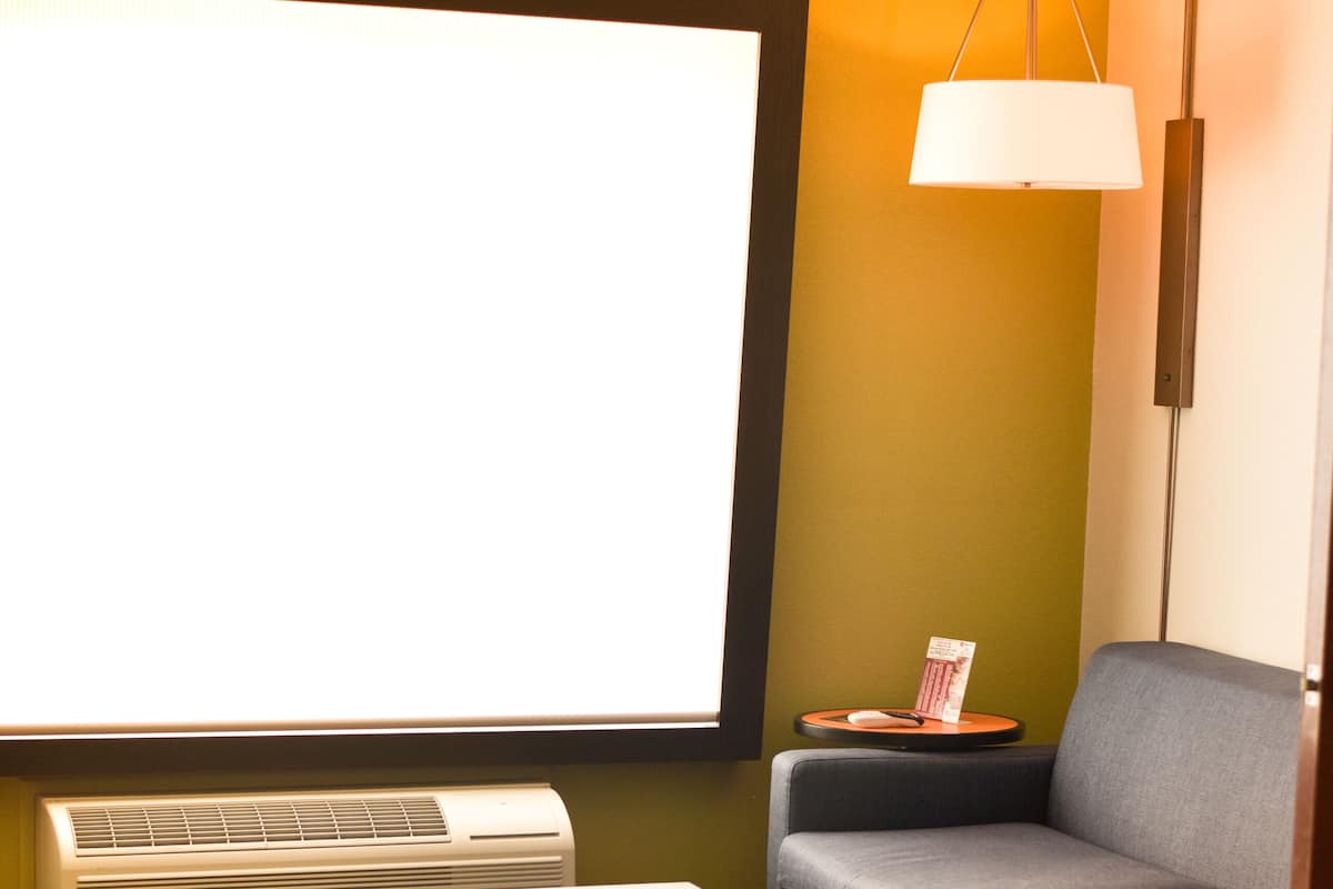 En moderne stue med et fladskærms-tv, en sofa, et sofabord og en gulvlampe.