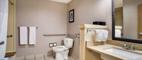 A bathroom with a toilet, sink, and shower.