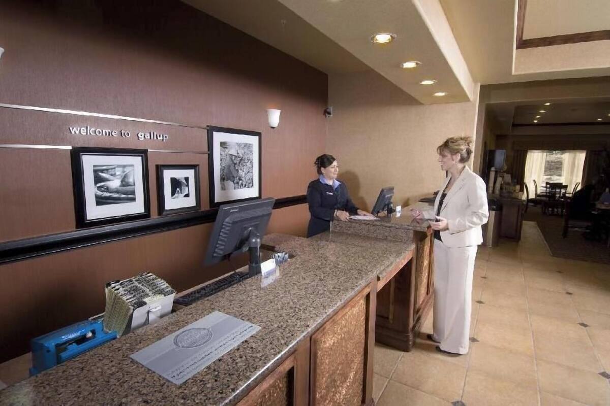 A reception desk with a 'Welcome to Gallup' sign, framed pictures on the wall, and a counter with a computer and paperwork.