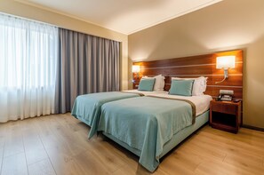 Twin kamer | Een minibar, een kluis op de kamer, een bureau, verduisterende gordijnen