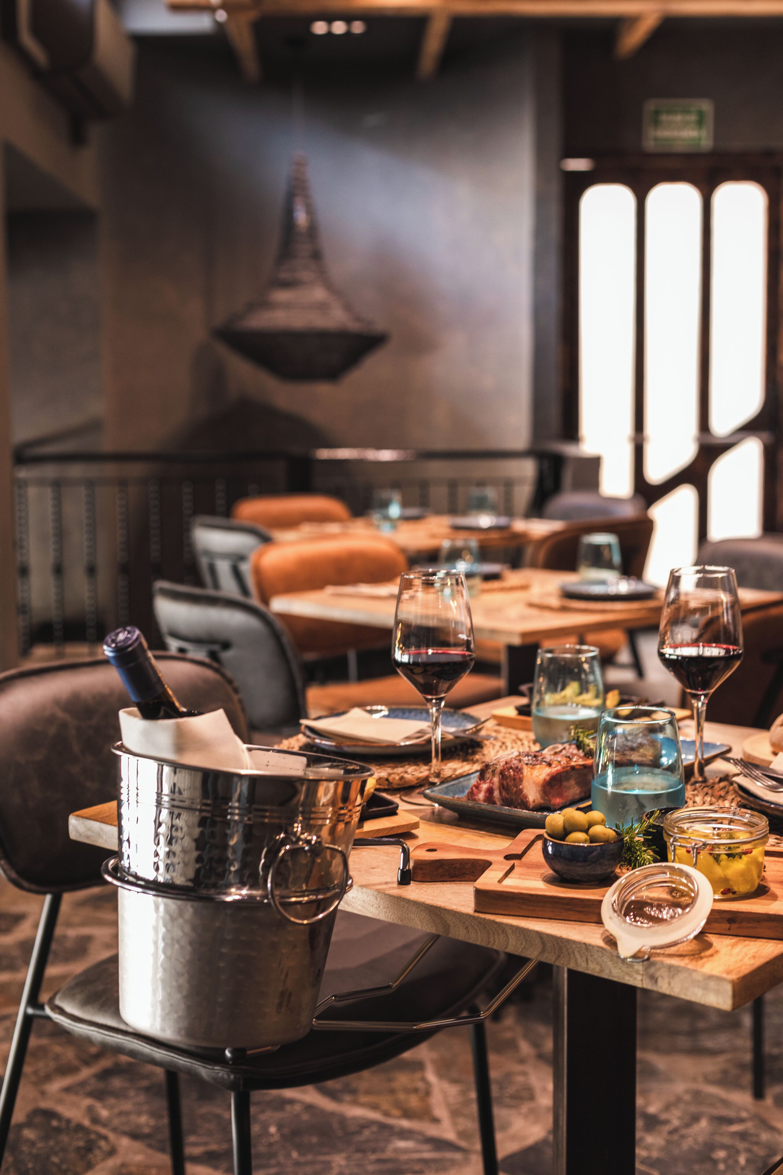 A dining table set with wine glasses, a bottle, and various dishes, suggesting a restaurant setting.