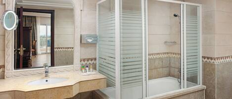 A bathroom with a sink, mirror, and glass-enclosed shower.
