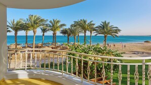 A balcony with a view of a beach, palm trees, and the sea. - Palm Royale Resort - Soma Bay (Soma Bay)