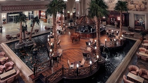 A spacious lobby with a central water feature, surrounded by seating areas and palm trees. - Palm Royale Resort - Soma Bay (Soma Bay)