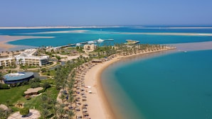 A resort with a beach, a marina, and a large building with a blue roof. - Palm Royale Resort - Soma Bay (Soma Bay)