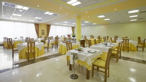 A large dining hall with multiple tables and chairs, arranged in rows. - Villa de Gijon (Gijon)