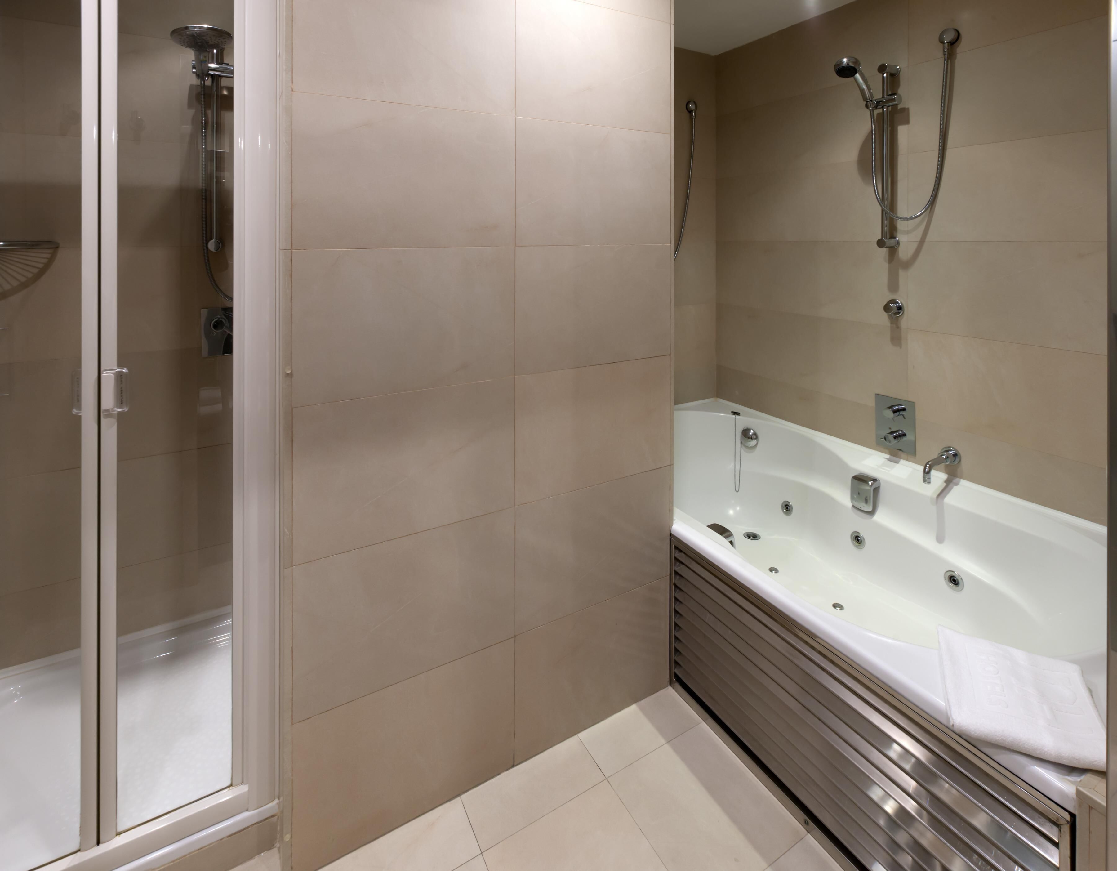 A modern bathroom with a glass shower enclosure, a freestanding bathtub, and a wall-mounted showerhead.