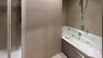 A modern bathroom with a glass shower enclosure, a freestanding bathtub, and a wall-mounted showerhead.